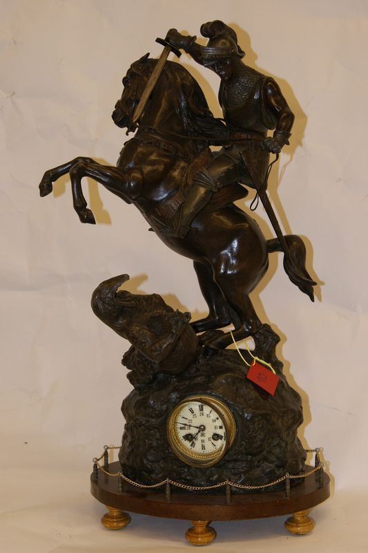 Orologio da tavolo sec.XIX, in metallo dorato con sovrastante cavaliere con drago, base legno, alt.