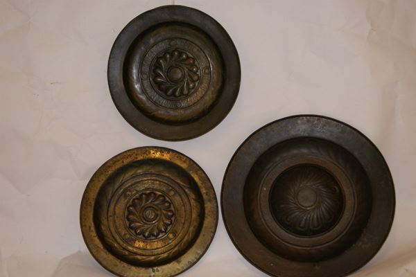 Tre elemosinieri sec.XVII, in ottone sbalzato, due incisi a girandola ed uno a budino, rispettivamente cm 51, 42, 41