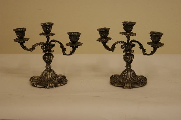 Coppia di candelieri in argento sbalzato a tre luci, gr 1770, alt.cm 19