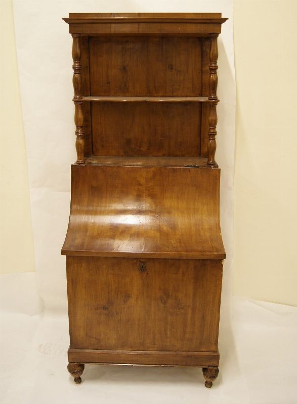 Portalegna, sec. XIX, in noce con sportello a ribalta e vani a giorno,  colonne tornite, cm 62x45x154