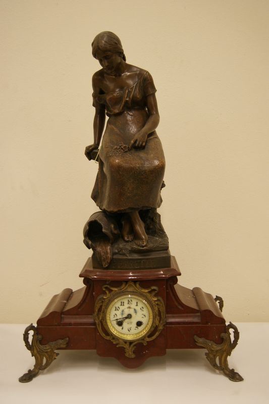 Orologio da tavolo, primi sec. XX, con base in marmo e sovrastante scultura raffigurante FIGURA FEMMINILE,in bronzo, cm 45x70