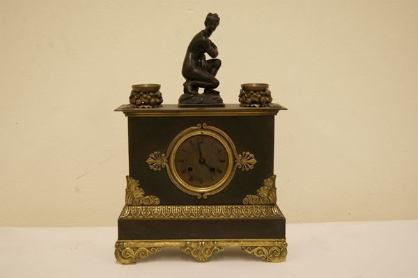 Orologio da tavolo, inizi del  sec. XX, in metallo dorato con sovrastante scultura raffigurante FIGURA FEMMINILE