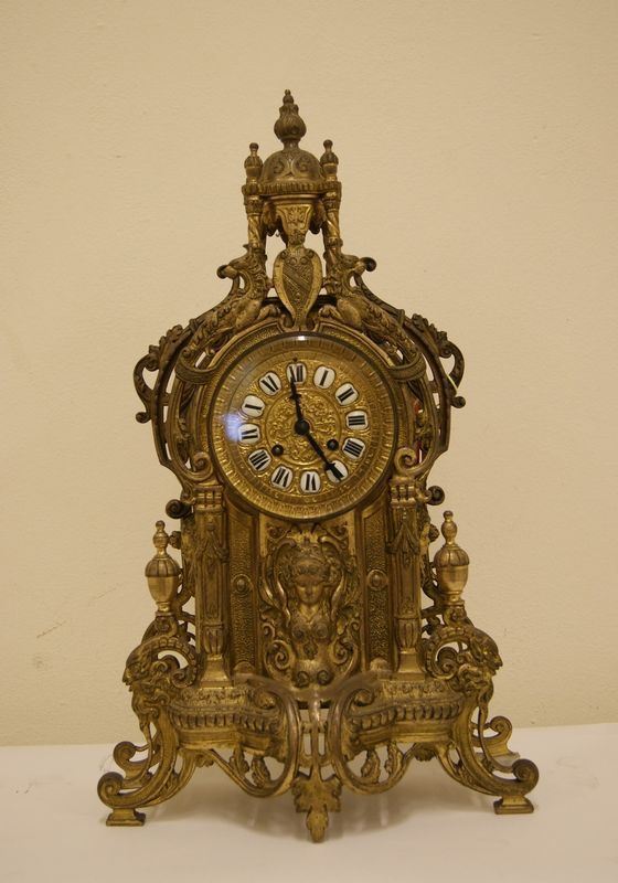 Orologio da tavolo, inizi del sec. XX, in metallo dorato e inciso, con animali e figure femminili a rilievo
