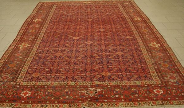 Tappeto persiano,  sec.XX,  fondo rosso a disegno bukara, cm 315x215, da restaurare