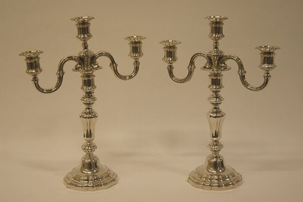 Coppia di candelieri, primi sec.XX,  in argento cesellato a tre luci gr. 1800