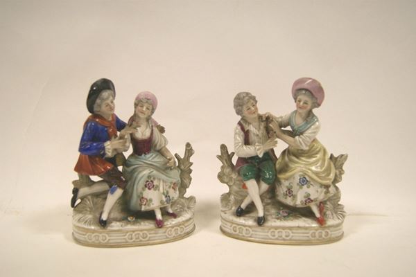Due gruppi in porcellana, inizi sec. XX, raffiguranti innamorati, alt. cm 17,5, difetti