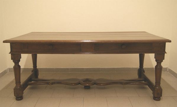 Tavolo scrivania, sec. XIX, in legno con piano in noce, a due cassetti e gambe tornite riunite da traversa sagomata, cm 198x107x80