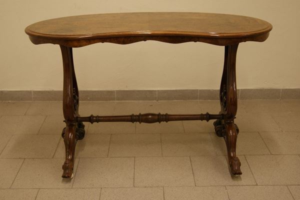 Tavolino basso, Francia inizi sec. XX, in legno sagomato a fagiolo, gambe mosse su rotelle, cm. 120x60x72