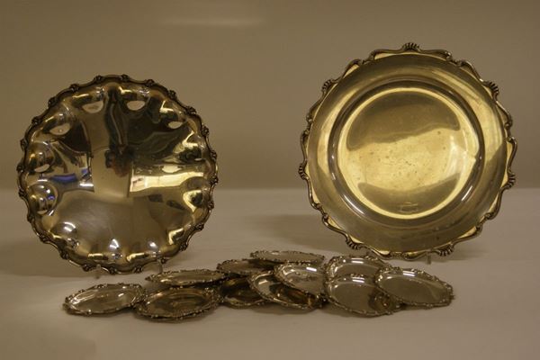 Due vassoietti in argento con bordo smerlato e dodici sottobicchieri in argento, tot. gr. 1660