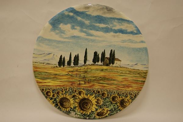 Piatto tondo,sec. XX,  in maiolica decorata a paesaggio con girasoli, firmato Ghironi, cm 86