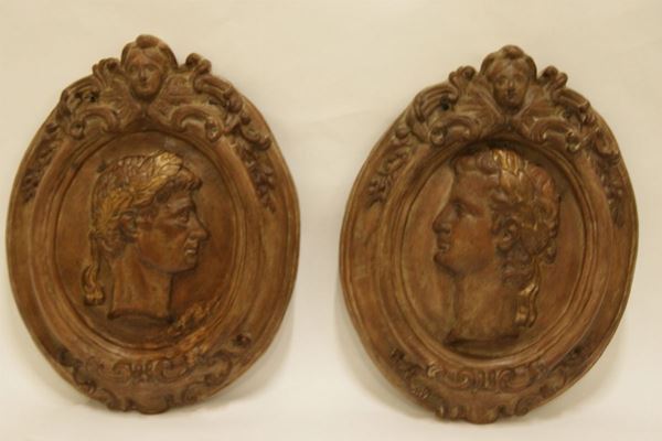 Coppia di altorilievi, sec. XIX, in terracotta, volti, cm.45x57