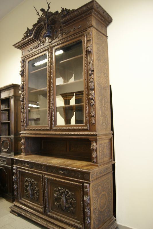 Vetrina ,Toscana sec. XIX, in legno riccamente intagliato a figure di animali e fiori, quattro sportelli e due cassetti, cm 174x62x345