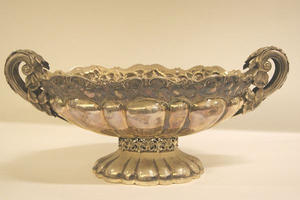 Centrotavola, sec.XX, in argento sbalzato con bordo sagomato e inciso a frutta e foglie,  gr. 5050