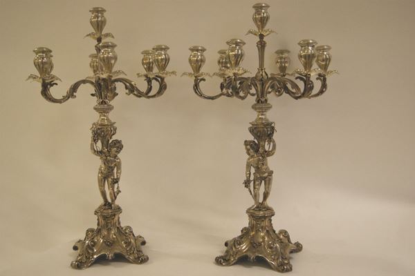 Due grandi candelabri, produzione Braganti Firenze, sec. XX, in argento cesellato a putti e fiori, tot. gr. 17.750, alt. cm 83 x 52