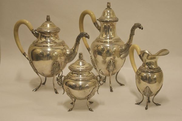 Servito da te' e caffe', sec. XX, in argento, composto da: caffettiera, teiera con manici in avorio e beccucci cesellati a teste di aquila, zuccheriera con manici a testine di putti e lattiera con manico in avorio, gr. 3000