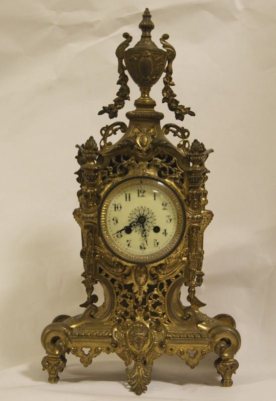 Orologio da tavolo, inizi sec. XX, in marmo con alzata in metallo dorato a figura cm 34,5 x15x50
