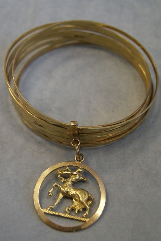 Bracciale in oro giallo , a otto cerchi con ciondolo a segno zodiacale, gr. 51