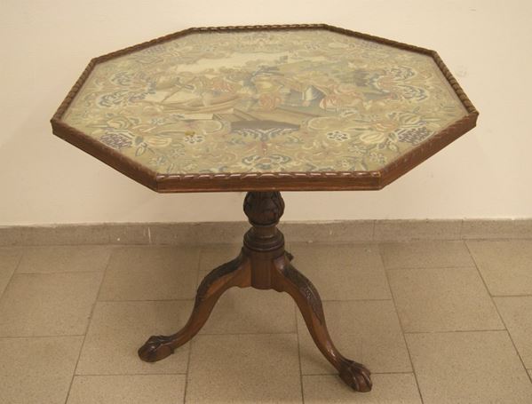 Tavolino, inizi sec.XX,  in mogano con piano ottagonale decorato con arazzo a scene settecentesche, gambe tornite su tre piedi sagomati, cm 87x76