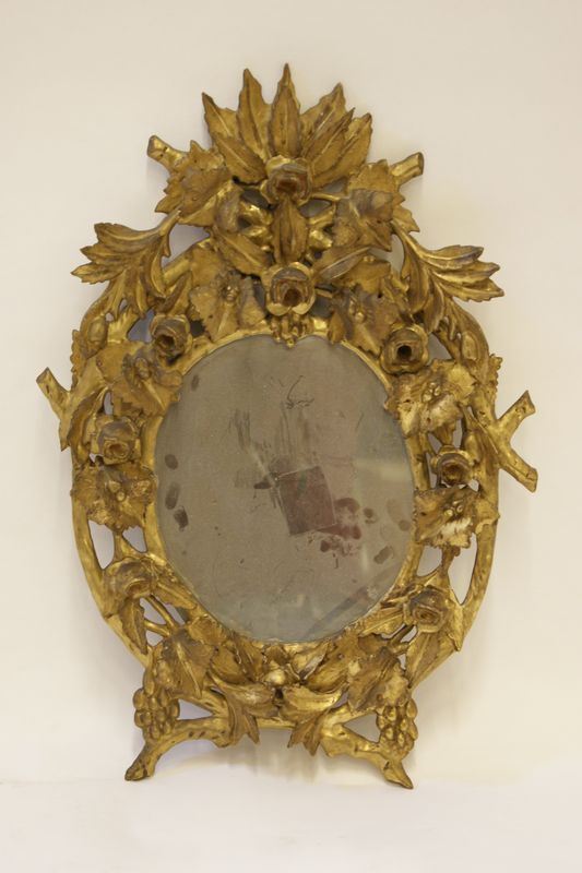 Specchiera ovale, sec. XIX, in legno dorato e intagliato a foglie e fiori, cm 57x41