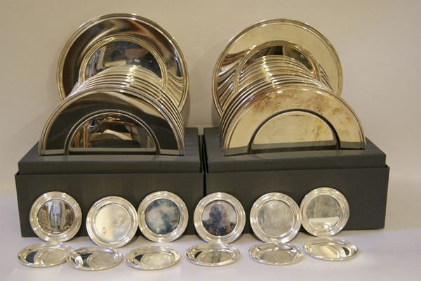 Dodici piatti in argento e dodici sottobicchieri in argento, tot gr. 5680