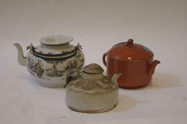 Tre teiere, Cina sec. XIX, in maiolica e porcellana decorate, alte da cm 7 a cm 8,5