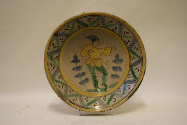 Grande piatto, Napoli sec. XVIII, in maiolica policroma con medaglone centrale, figura in maschera e bordo decorato, diam cm 48, difetti