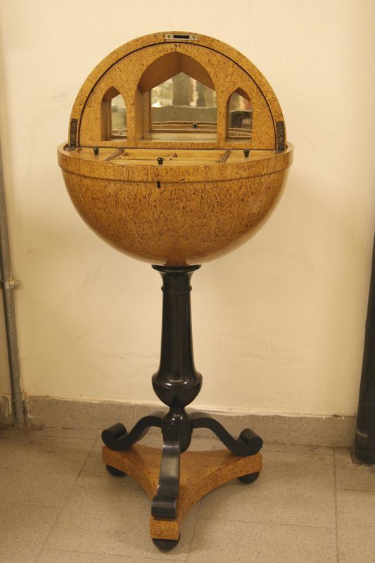 Tavolino da lavoro, in stile Biedermeier, in ciliegio intarsiato e radica di tuja, di forma sferica con calotta apribile, sostegno ebanizzato, alt. cm 112