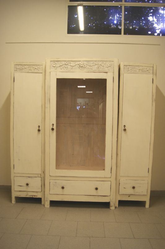 Libreria, inizi sec. XX, a  tre corpi, in legno laccato bianco, tre sportelli uno dei quali in vetro e tre cassetti, cm 194x50x197