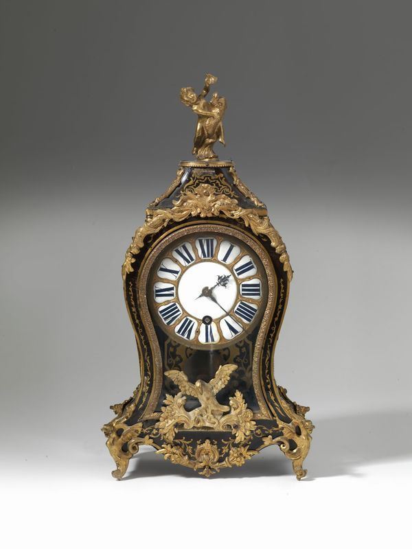 Orologio da tavolo, metÃ  sec. XVIII, cassa di forma sagomata listrata in tartartaruga intarsiata in ottone,  finale con putto su delfino in bronzo dorato, quadrante in smalto con numeri romani, meccanismo firmato. P. E. GamotaLitte, alt. cm 55, danni