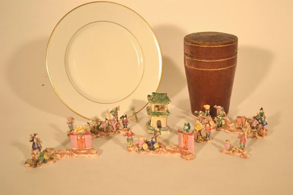 Serie di quarantotto piccolissime figure, arte orientale, fine sec. XIX,  in ceramica invetriata policroma, alcune figure sono racchiuse in  astuccio cilindrico; ed un piatto in porcellana bianca con rigo oro