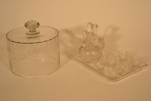Gruppo di cristalli,  secc. XIX-XX, composto da: una grande campana circolare cilindrica;  vassoietto rettangolare con due bottiglie globulari e sei bicchierini  incisi a motivi vegetali (10)