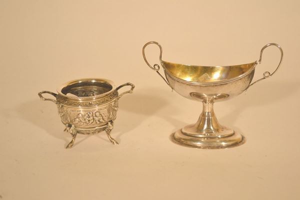 Lotto composto da: piccola coppa ovale in argento con interno  dorato, inizio sec. XIX, cm 11,5x15 ed una zuccheriera circolare sbalzata con puttini e festoni, manici a voluta, fine sec. XIX, alt. cm 6,4