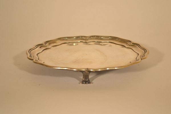 Alzata circolare sagomata,  fine sec. XIX, in argento con  bordo rialzato scalettato, tre piedini a voluta, diam. cm 29,5