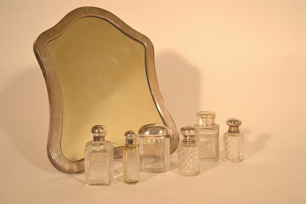 Servito da toilette composto in argento, metallo argentato e vetro composto da: specchio sagomato con cornice liscia, cm 42,5x36 e sei fra flaconi e scatole in vetro con coperchi in metallo, fine sec.XIX-XX (7)