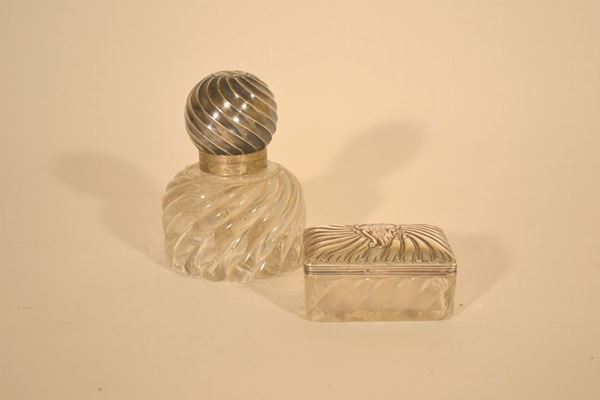 Calamaio e scatola rettangolare differenti tra loro in vetro intagliato e coperchi in argento; calamaio con coperchio staccato, alt. cm 15, scatola cm 10x6,5,  inizio sec. XX (2)