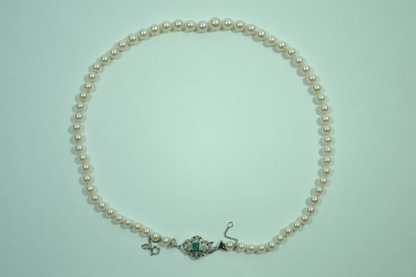 Collana in perle, oro bianco e smeraldo realizzata ad un filo di perle poste in gradazione, diam. da mm 8  a mm 6, fermatura sagomata in oro bianco traforato decorata da piccole rose di diamante e centrata da uno smeraldo carrÃ¨, g 31