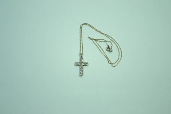 Pendente in oro bianco e diamanti  modellato come una croce, i bracci decorati da una linea di brillanti taglio cuscino, con catena in oro bianco a maglia sottile, gr. 5