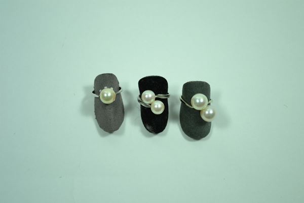 Tre anelli in oro bianco, di cui due con perle montate in contrarie' uno con perla singola, gr.12 (3)