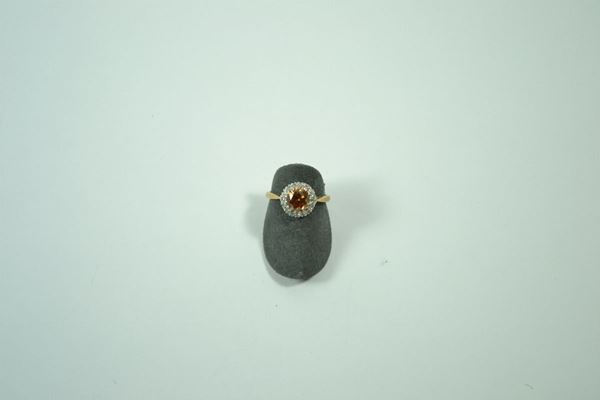 Anello in oro giallo con topazio arancio  entro cornice di piccolissimi brillanti, gr. 3