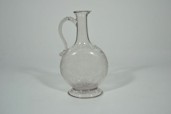 Brocca, sec. XVIII, di forma schiacciata, in vetro inciso on volute e fiori, presa a volute, alt. cm 24,5