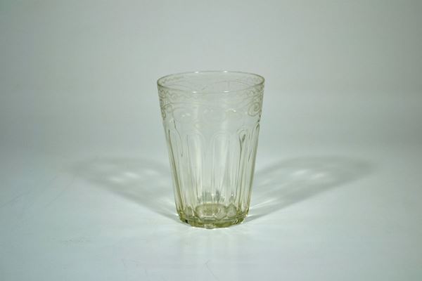 Vaso a bicchiere, sec. XVIII, in cristallo, bordo inciso con motivi di fiori stilizzati, decorato da alta scanalatura, alt. cm 13,5 ed una piccola bottiglia, fine sec. XVIII, di forma ovoidale in vetro incisa con  fiocchi e festoni di fiori, alt. cm 24, completa di tappo (2)