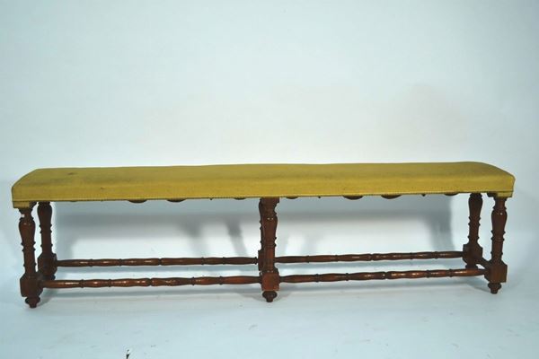 Panchetto da parete, inizi sec. XVIII, in noce a patina bionda, fascia  sagomata, gambe tornite a balaustro e riunite da traverse a rocchetto,  ricoperto in filaticcio giallo, lungh. cm  210, alcuni restauri