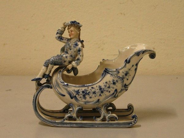 Scultura, sec. XIX SLITTA CON FIGURA in porcellana decorata, cm 15x19