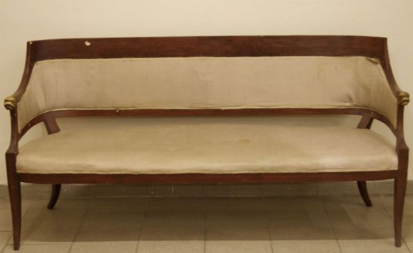 Divano, Toscana, inizio sec. XIX in legno tinto con spalliera a fascia arcuata, terminante in braccioli intagliati,  teste di delfino dipinte, sedile imbottito, gambe a sciabola, danni