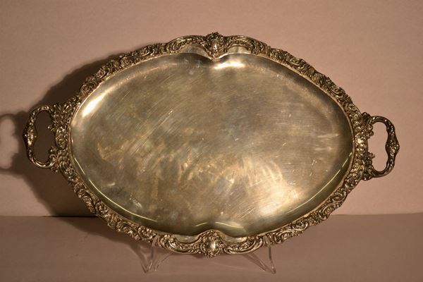 Guantiera, di forma ovale in argento con bordo sbalzato e cesellato avolute, cm 58x35,5, g 1600