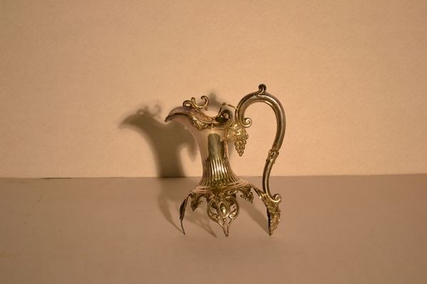 Montatura per caraffa da vino, in argento cesellato, manico ad esse unitoal corpo da un grappolo d'uva ed un mascherone, beccuccio sagomato, g 320