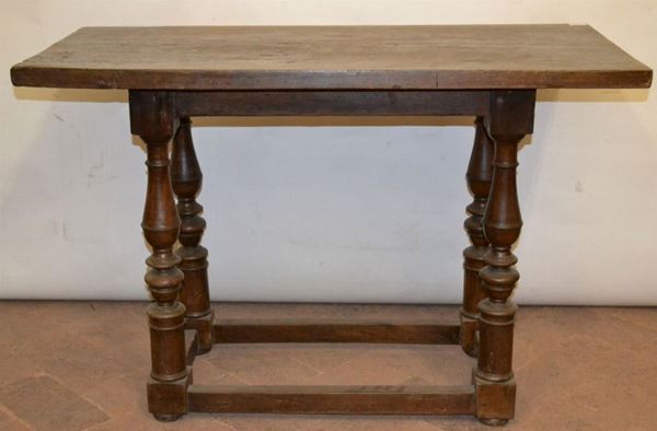 Tavolo, Bologna inizi sec. XVII, in noce a patina scura, piano rettangolare, eleganti gambe tornite a balaustro su piedi a dado, riuniti  da traverse rettilinee, cm 114x57x77,  piano non pertinente