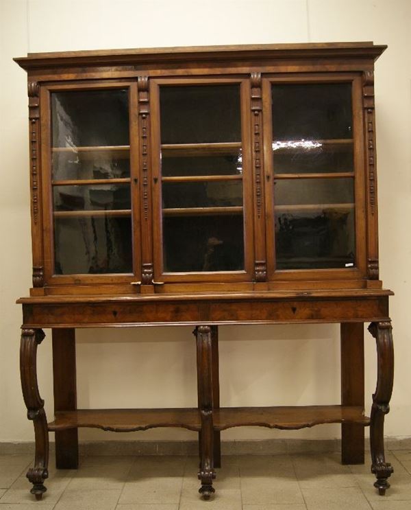 Vetrina, Toscana, sec. XIX, in noce, a due corpi, con sovrastanti tre sportelli in vetro, sottostanti tre cassetti e vano, sostegni sagomati, cm 178x50x126