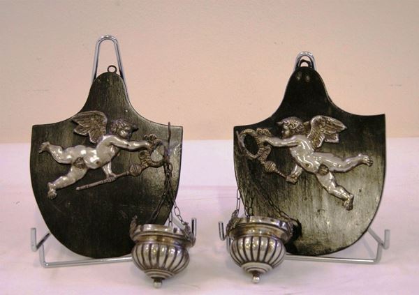 Coppia di acquasantiere, sec.XVIII, in argento sbalzato, con sostegni raffiguranti putti applicati su supporti in legno dipinto nero, difetti