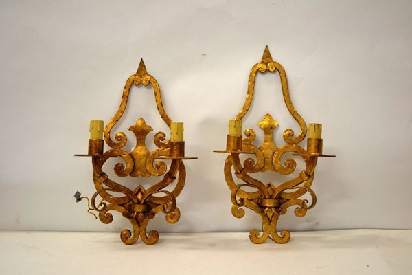 Coppia di appliques, in metallo dorato e forgiato a volute contrapposte,ciascuna a due luci, complete di applicazione elettrica, alt. cm 41(2)